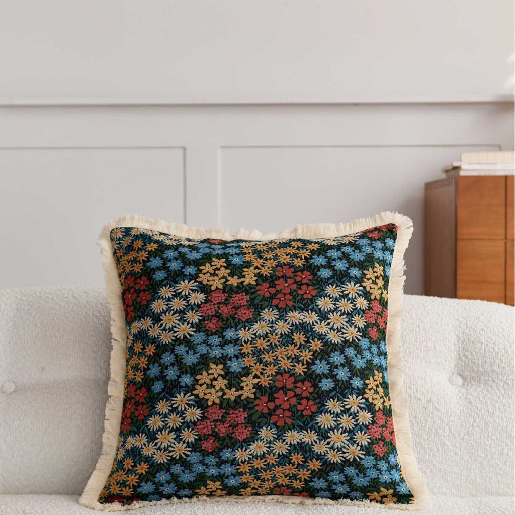 Edith Midnight Meadow Cushion, dark ditsy floral tapestry on a sofa