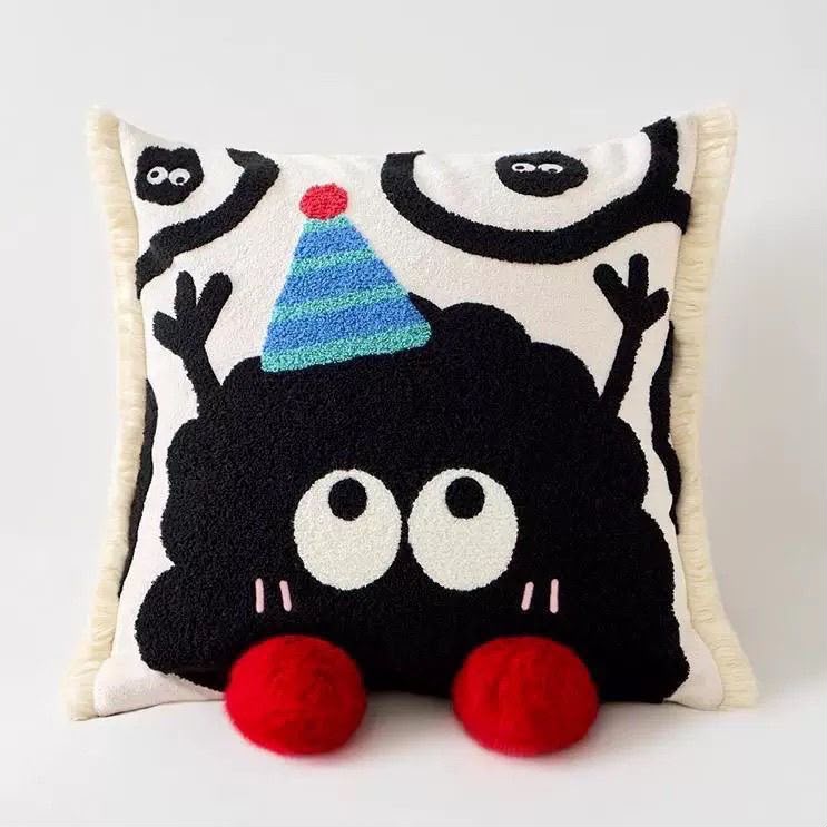 Pippin Party Hat Soot Cushion, cream fringed cushion with a black embroidered character in a striped party hat and red pom-pom feet
