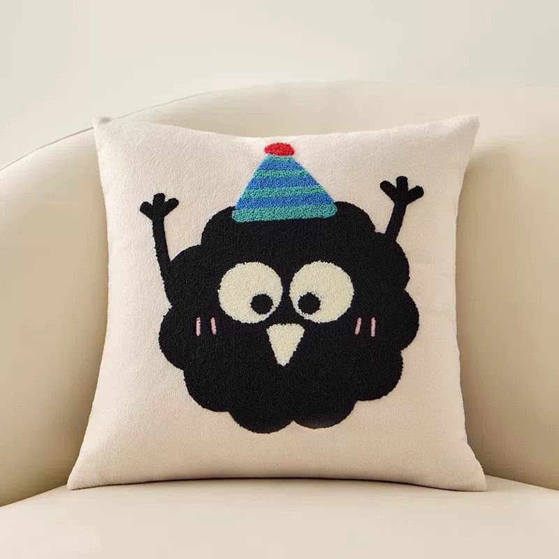 Wilma Happy Soot Cushion, cream cushion with a black embroidered character in a striped party hat