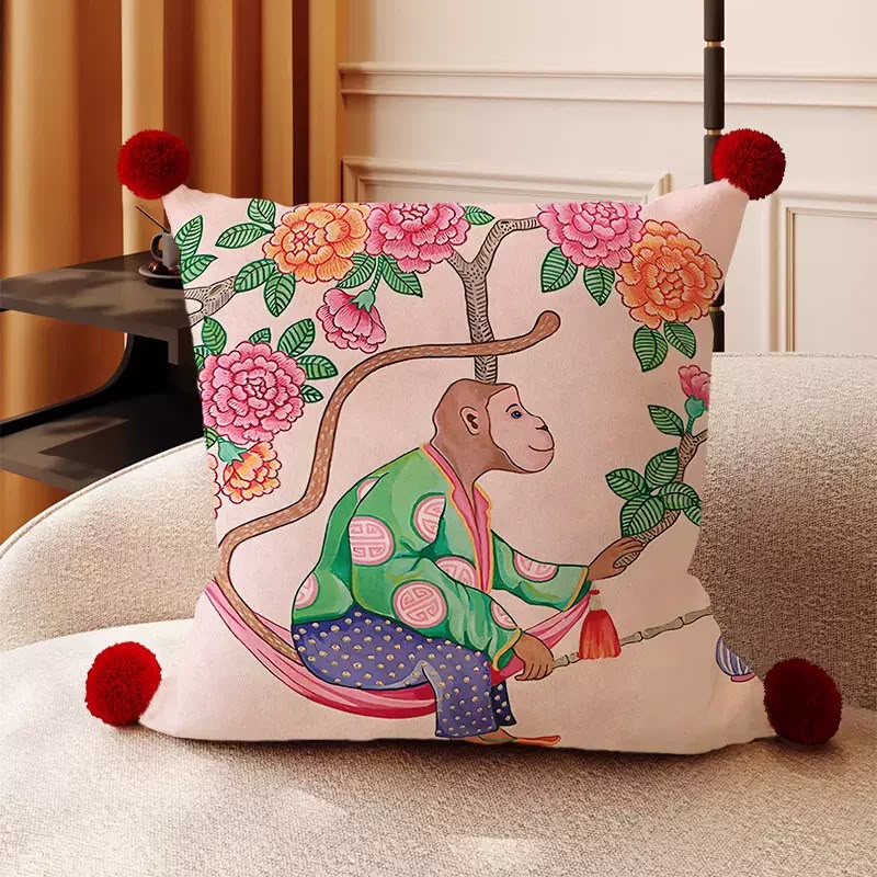Mirabel Monkey Chinoiserie Cushion, pink cushion with a painted monkey on a peony branch and red pom-pom corners