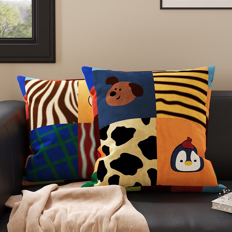 Scout Patchwork Penguin and Pup Cushion on a sofa with the matching patchwork cushion