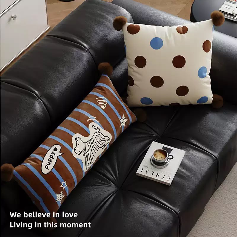 Puppy bolster and spot cushion on a sofa