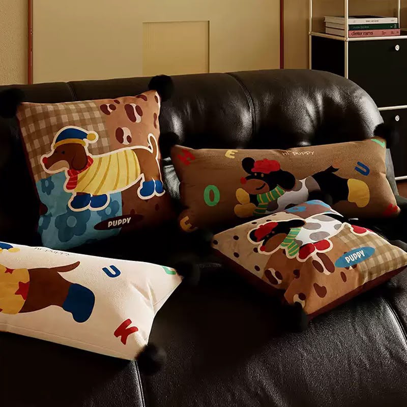 Poppy Patchwork Puppy Cushion styled on a leather sofa with the matching puppy cushions