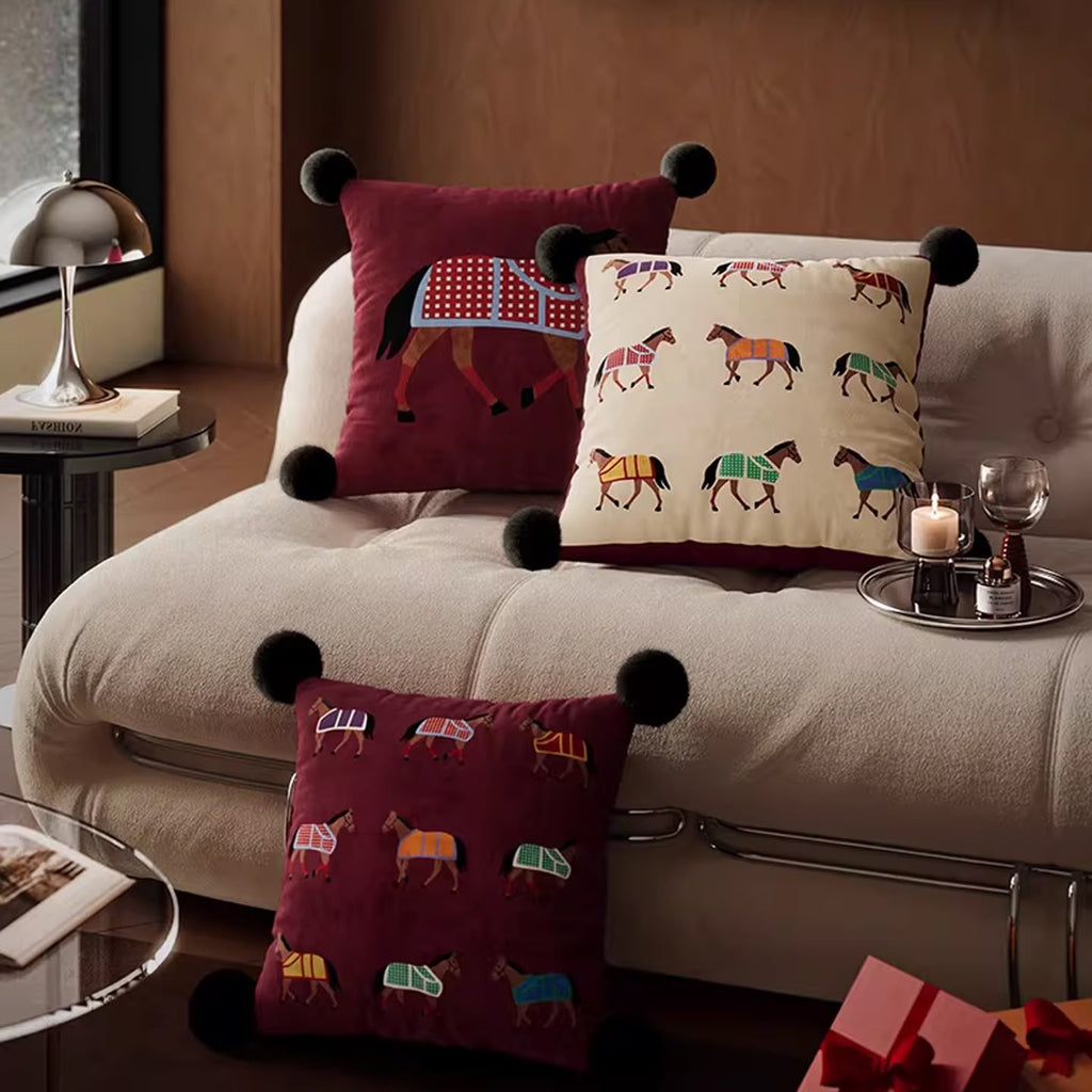 Equestrian horse cushions grouped on a cream sofa