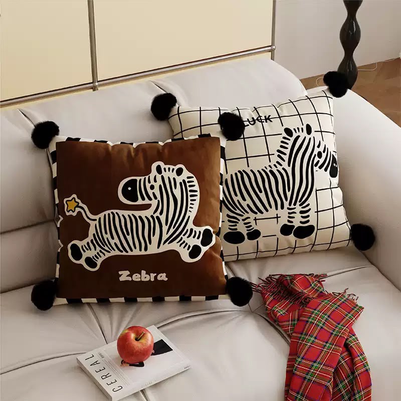Zebra cushions styled on a cream sofa with a tartan scarf
