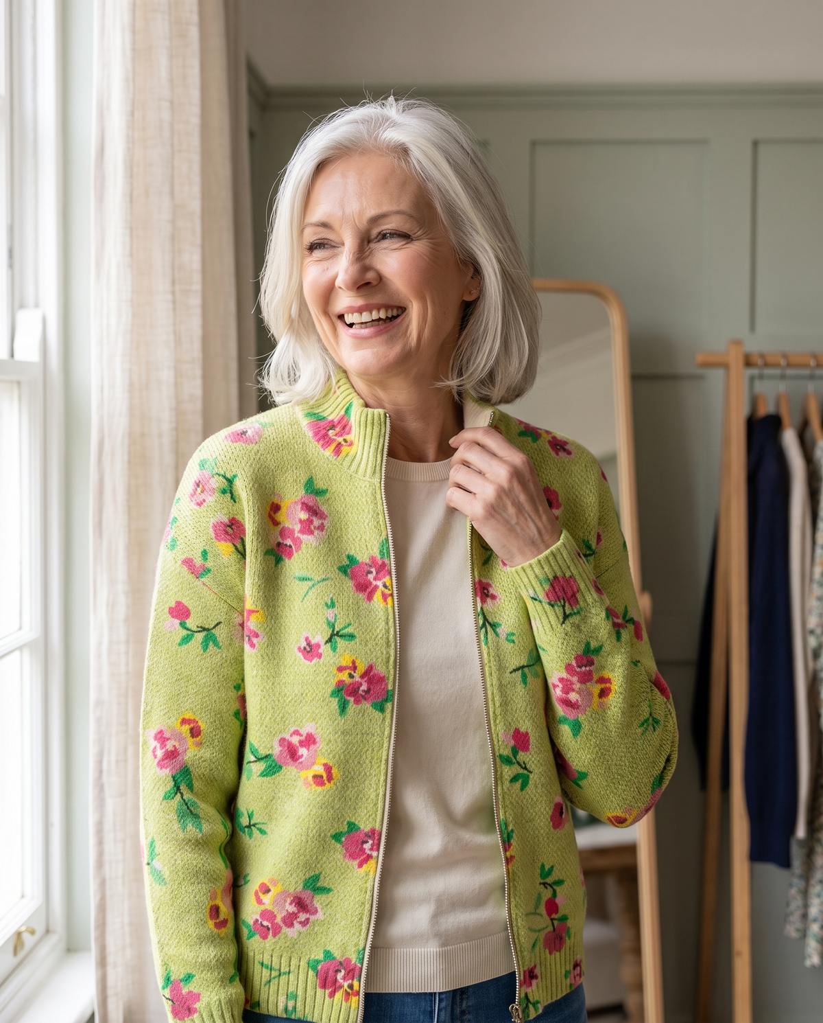 Woman in her 60s wearing the Clemency rose meadow zip cardigan in a boutique