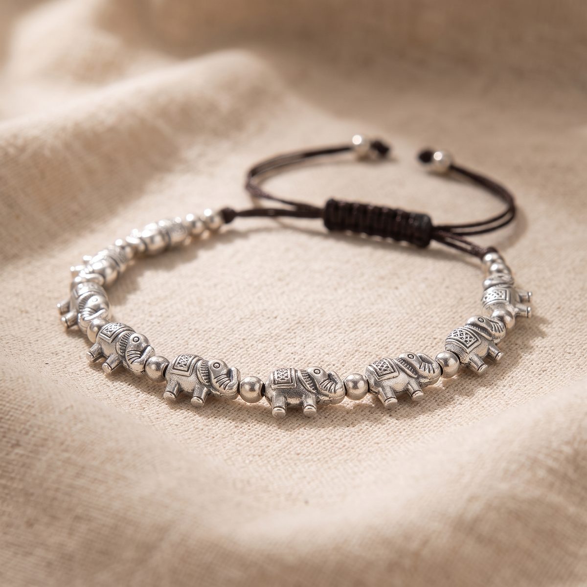 Tabitha Silver Elephant Bead Cord Bracelet on linen