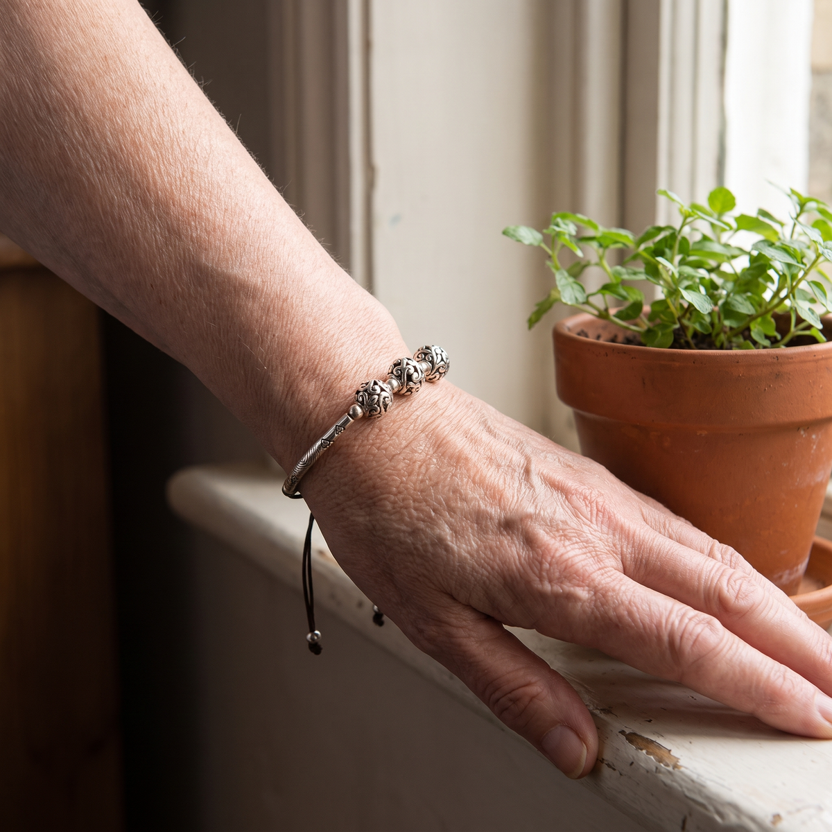 Verity Engraved Silver Bar Cord Bracelet worn on the wrist