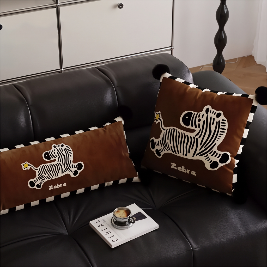 Zebra cushions on a dark leather sofa