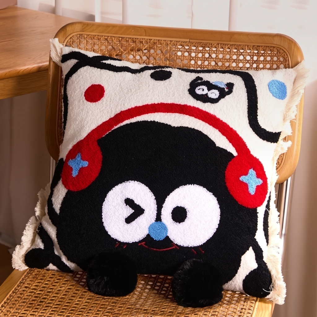 Melody Headphones Soot Cushion, cream fringed cushion with a black embroidered character wearing red headphones
